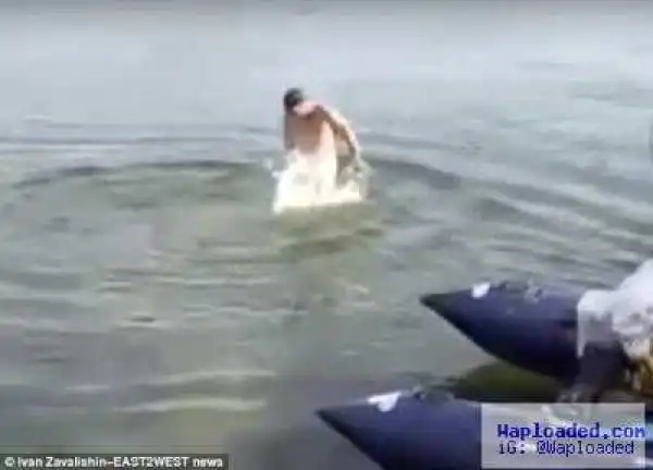 Naked swimmer rushes out of lake after fish 